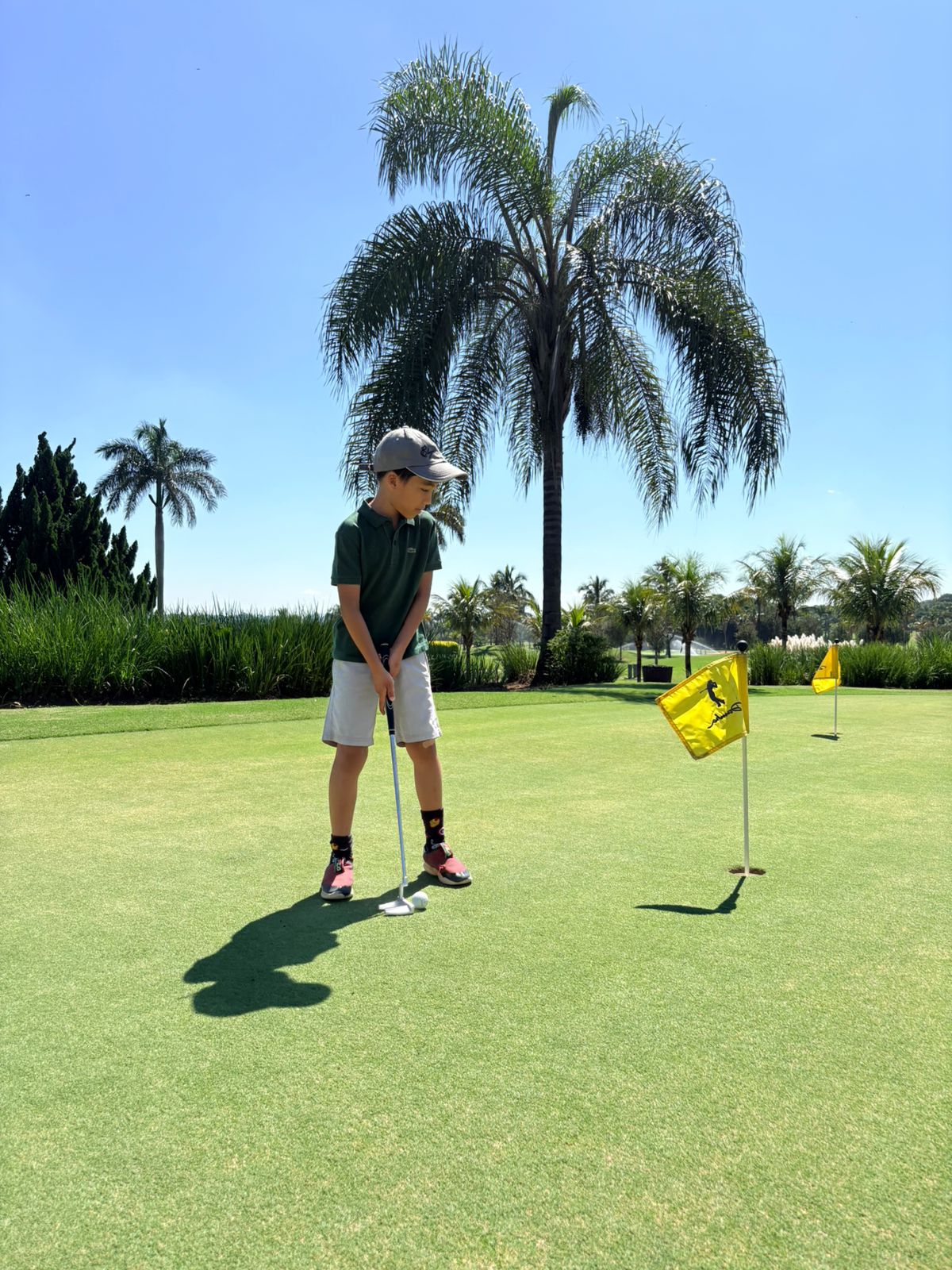 Criança praticando putt no green do Damha Golf Club